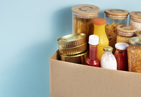 Cardboard box full of dried food goods and condiments