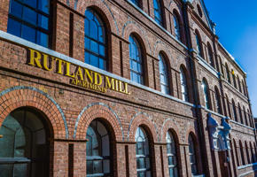 Exterior shot of Rutland Mills apartments with the sign