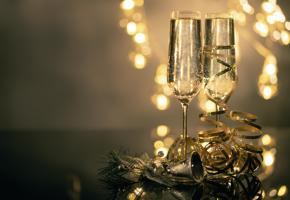 Champagne glasses on a table with festive lights in the background