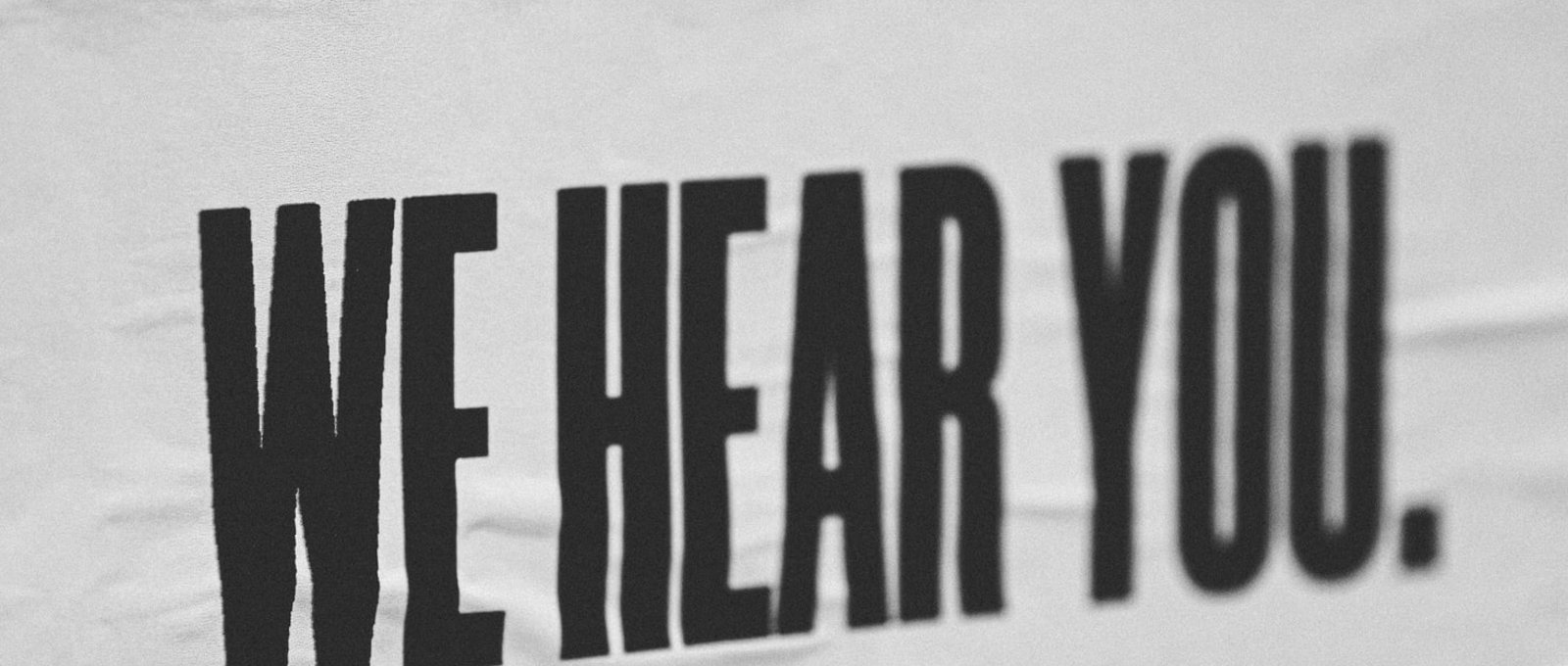 Photo of a banner that reads 'We hear you'