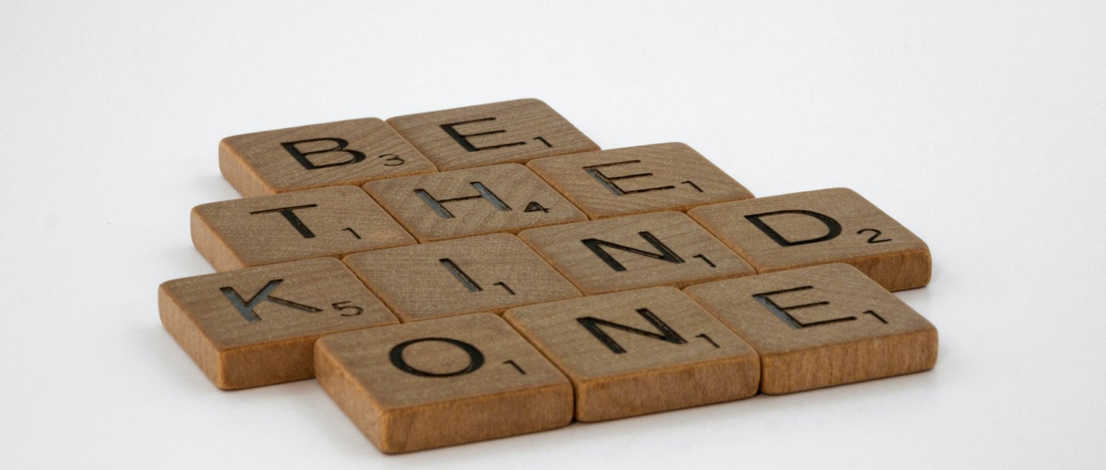 Photograph of wooden tiles spelling out 'Be the kind one'