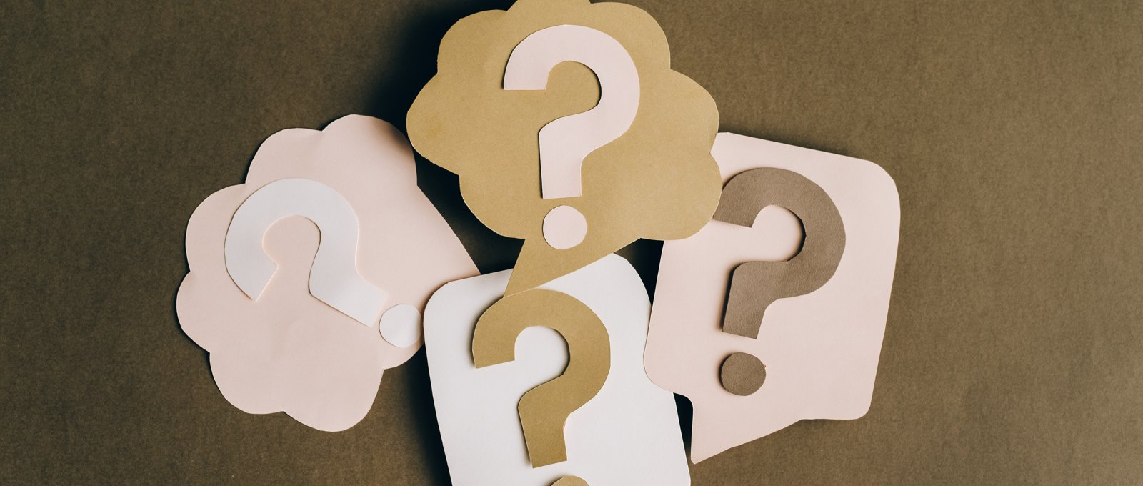 Photograph of four question marks made of paper cutouts