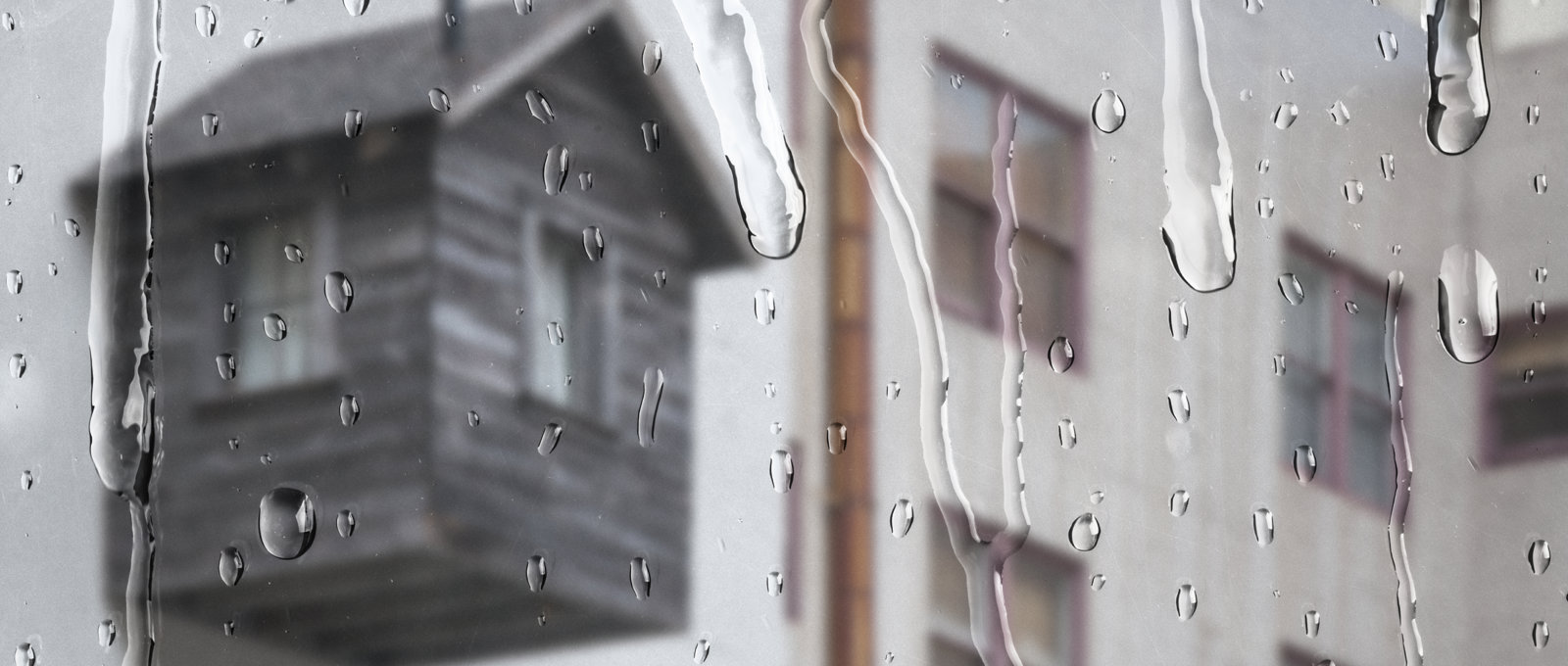 White Apartment Through Window With Rain Drops